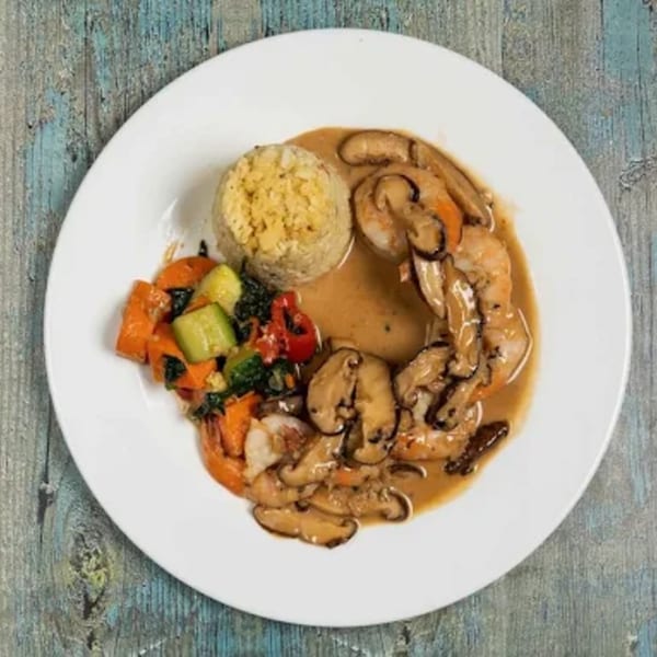 Sage Restaurant's shrimp and mushroom dish with rice and mixed vegetables on a white plate.